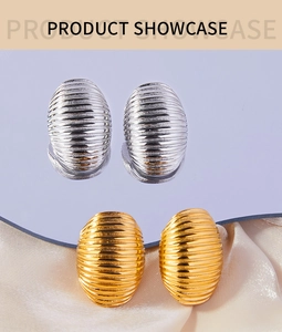 Detailed view of oval textured earrings in gold and silver finish with ribbed patterns