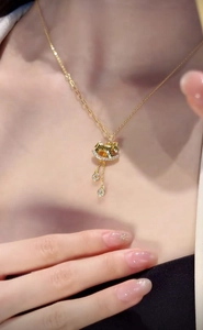 Close-up of a zircon rocking horse necklace with sparkling diamond pendants on a model