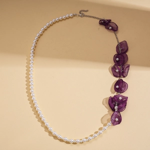 Macro shot of asymmetrical faux pearl and purple chiffon flower pendant necklace