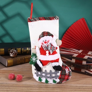Detail of fabric Christmas stocking with 3D snowman pattern and red plaid cuff trim