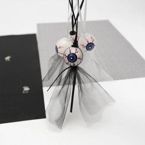 Close-up of Halloween ghost eyeball hanging decoration with mesh fabric and bloodshot eye