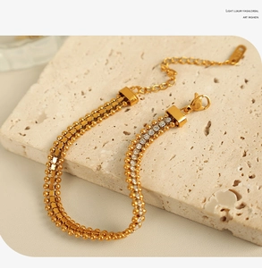 Detail of gold chain bracelet with embedded zircons and adjustable lobster clasp