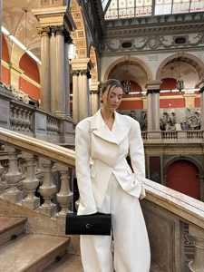 Detail of the high-quality white tailored blazer suit with wide shoulders and wide-leg pants
