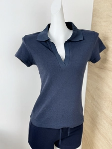 Close-up of deep blue short-sleeved V-neck polo shirt with fine knitted texture details