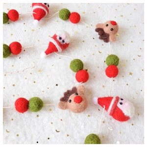 Nahaufnahme von Wollfilz Weihnachtsmann und Rentier Anhängern in Rot und Weiß