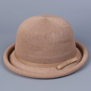 Detail of knitted dome bowler hat with breathable mesh texture and elegant side bow