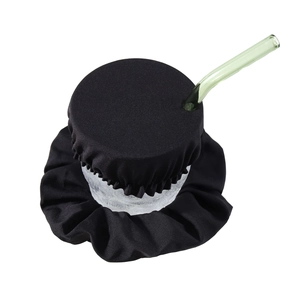 Detail showing black fabric scrunchie used as a drink cover with green straw insert