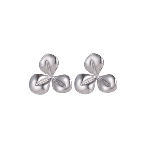 Macro shot of silver titanium steel earrings in a minimalist three-petal flower design