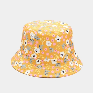 Detailed view of yellow floral reversible sun hat with white flower and blue leaf pattern