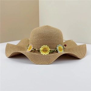 Détail de broderie tournesol sur un chapeau de paille à larges bords ondulés