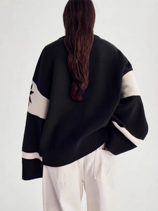 Oversized black and white knitted Christmas sweater with striped sleeves and back view