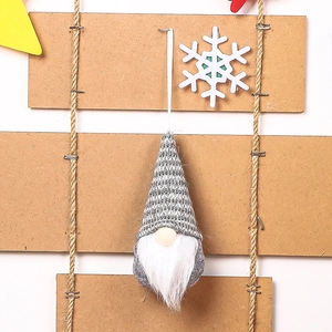 Detail of a gray knitted Christmas gnome ornament with white beard and wooden nose