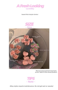 Detailed view of pink camellia bow hair clips with peach and heart resin charms