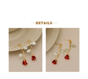 Detail of red rose drop earrings with golden stems and green leaves in vintage style