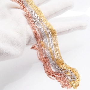 Detailed view of triple water wave chains in silver, rose gold and gold finish