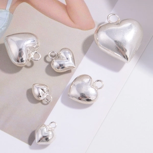 Detailed view of multiple sizes of 925 sterling silver heart-shaped pendant charms