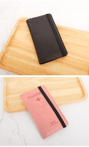 Detailed view of black and pink faux leather passport wallets with elastic closures