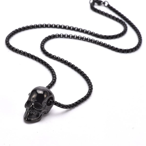 Detailed close-up of a 3D black stainless steel skull pendant with matching box chain