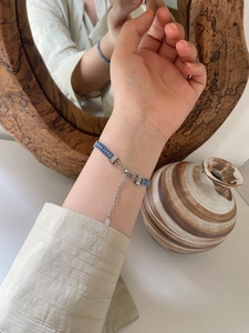 Detailed close-up of blue mermaid bead bracelet on wrist with adjustable steel chain