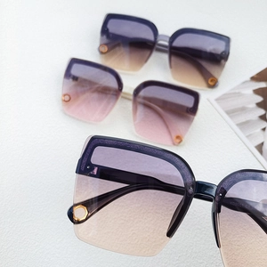 Close-up of stylish oversized sunglasses with purple gradient lenses and glitter frames
