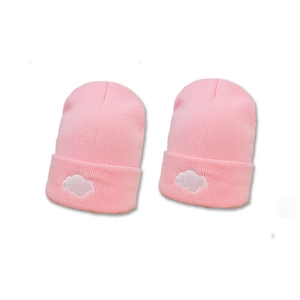 Pair of pink knitted beanies for women with a cute white cloud embroidery detail