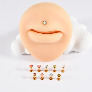 Macro view of gold plated stainless steel labret studs featuring colorful opal gemstones