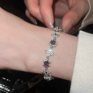 Close-up of a silver zircon bracelet with purple gemstones on a woman's wrist