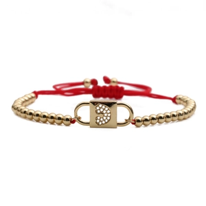 Adjustable red rope bracelet with gold metal beads and a sparkling rhinestone lock charm