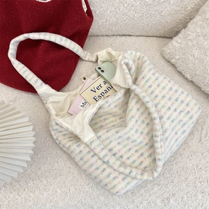 Detail of colorful plaid plush tote bag showing soft faux fur texture and large capacity