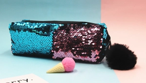 Macro shot of two-tone reversible sequins on a pencil case with a black fur pom pom charm