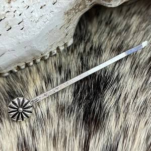 Detailed close-up of silver concho hair pin on fur with bohemian western style