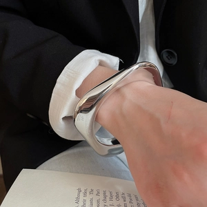 Detail of silver geometric wide cuff bracelet with polished irregular sculptural surface