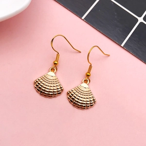 Golden scallop shell earrings with 925 hallmarked hooks on a grid background