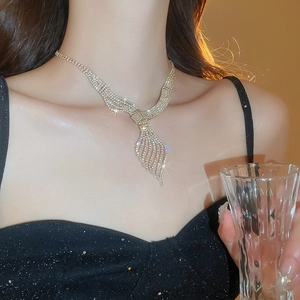 Close-up of elegant gold leaf necklace with sparkling rhinestones worn by a model