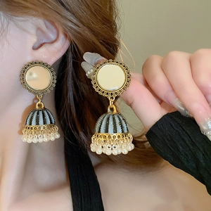 Detail of vintage ethnic Jhumka earrings with blue enamel bell and white pearl tassels