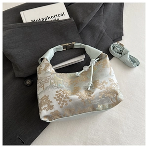 Detail of light blue silk jacquard handbag with traditional embroidery and detachable strap
