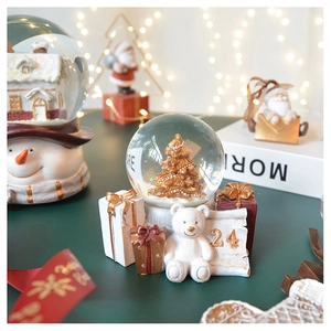 Macro detail of Christmas snow globe with golden tree and white bear base display
