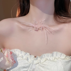 Close-up of elegant pink feather butterfly necklace with beads worn by a model