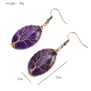 Detail view of handmade tree of life earrings with natural amethyst and bronze wire
