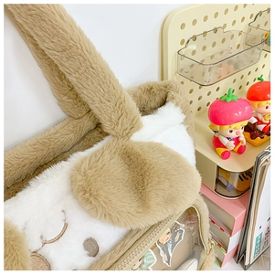 Close-up of plush puppy tote bag featuring a transparent side pocket and soft texture