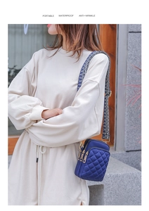 Waterproof quilted nylon crossbody phone bag with ethnic patterned wide strap on a model