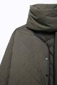 Detail shot of army green diamond quilted jacket featuring metal snaps and matching scarf