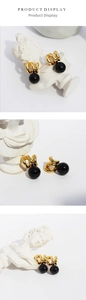 Detail of vintage gold triple rings with polished black onyx bead on a white pedestal