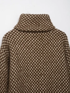 Détail du motif à carreaux marron et beige sur un blouson aviateur en tricot à col montant