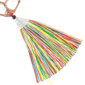 Close-up of vibrant colorful tassels with ornate silver metal cap and hand-woven details