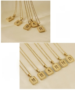 Detalle del colgante de letra en acero inoxidable bañado en oro de 18K con acabado mate cepillado