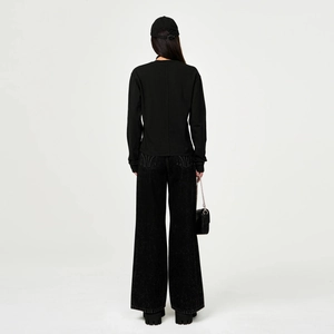 Minimalist black long sleeve top and wide leg denim trousers shown from back view