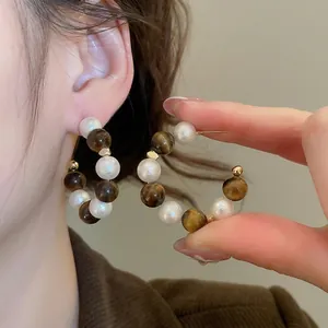 Boucles d'oreilles créoles en oeil de tigre et perles avec accents en métal doré
