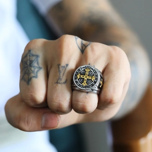 Detailed view of Saint Benedict Medal ring in silver and gold on a male hand