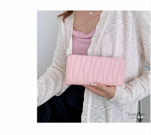 Pink PU leather long wallet with elegant 3D wave texture held by a female model